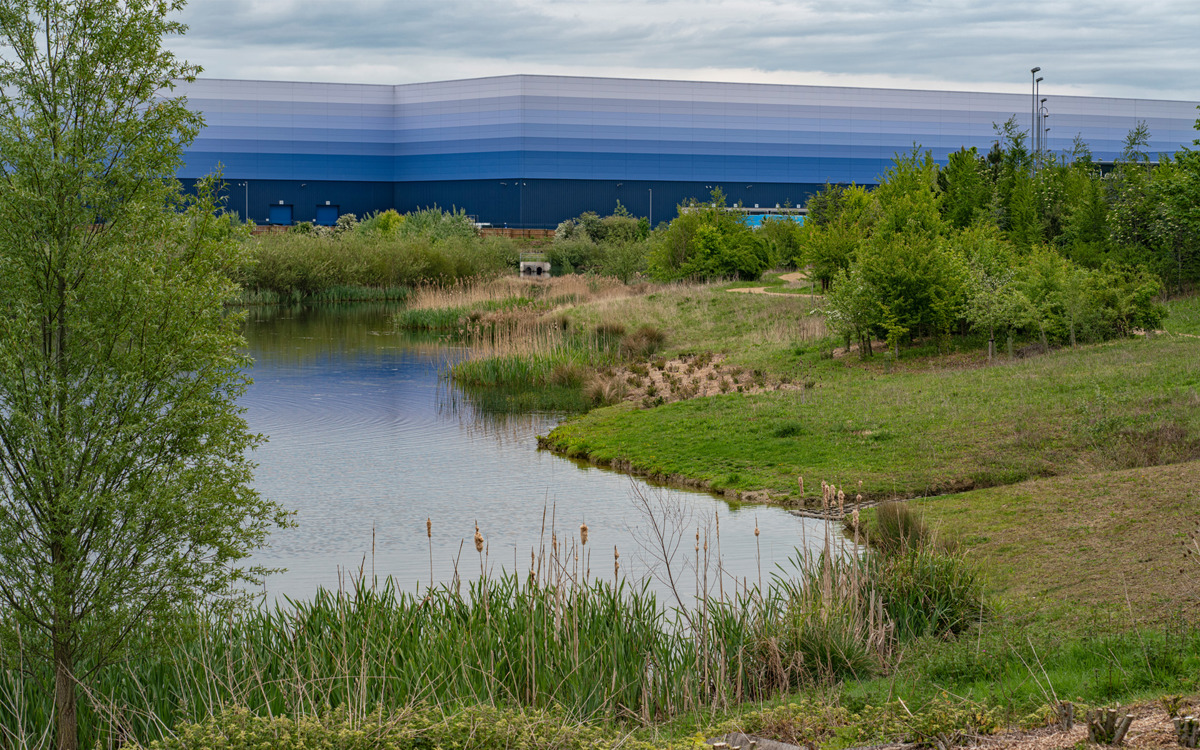 Magna Park lake with blue warehouse in background.