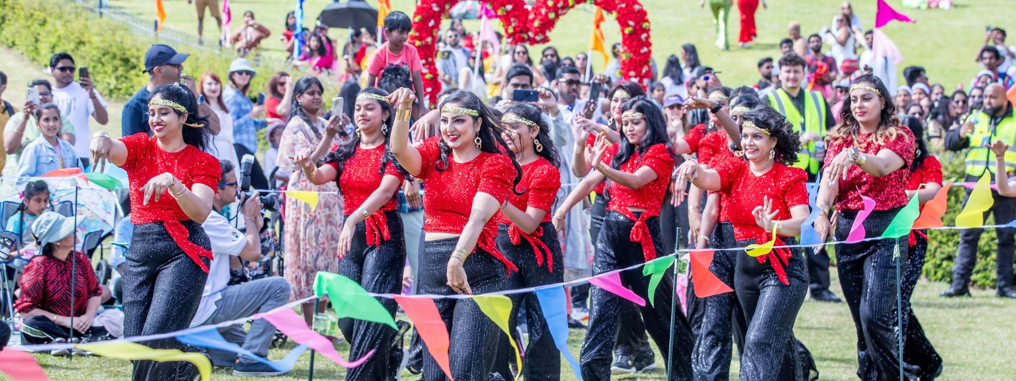 Group of people doing a dance performance in vibrant red sequins