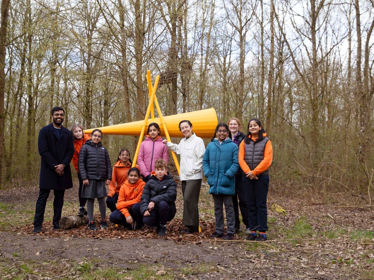 Group of adults and children in woodland with large listening cone