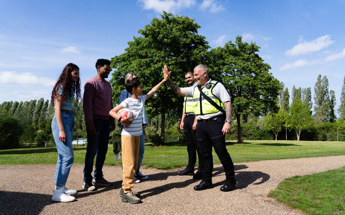 Park Enforcement Officers high fiving family