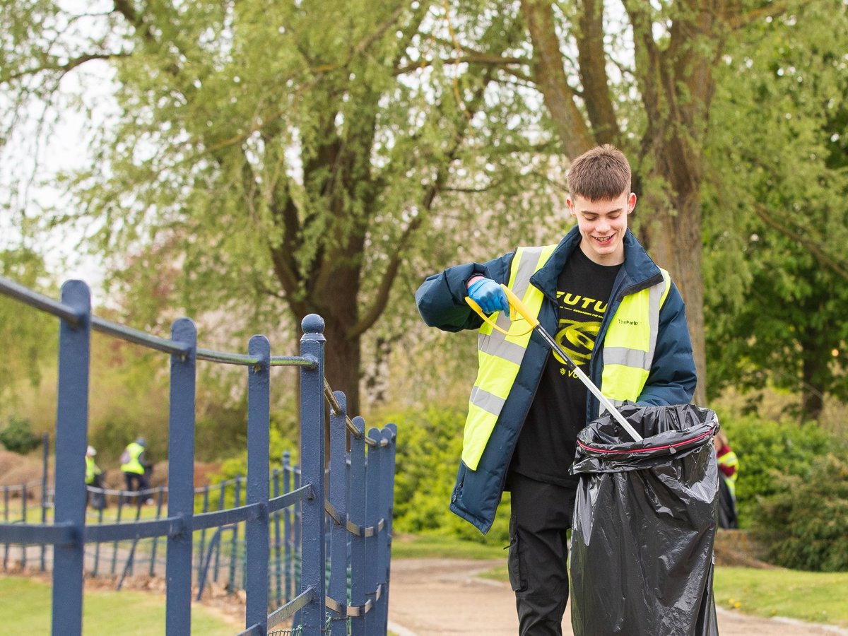 A young man litter picking in a Campbell Park