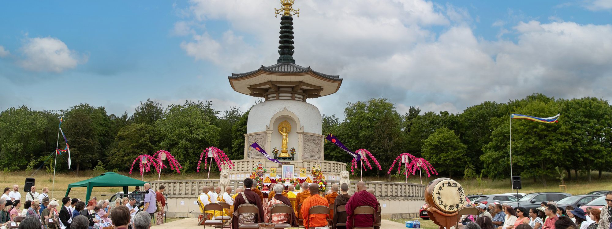 Monks and member of the public at commemoration event at the Peace Pagoda