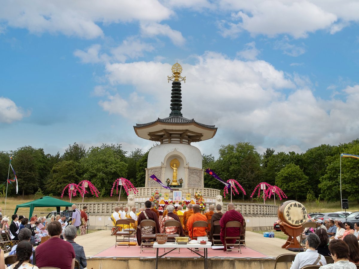 Monks and member of the public at commemoration event at the Peace Pagoda