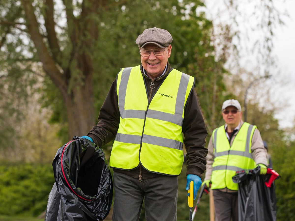 Person litter picking holding bin bag