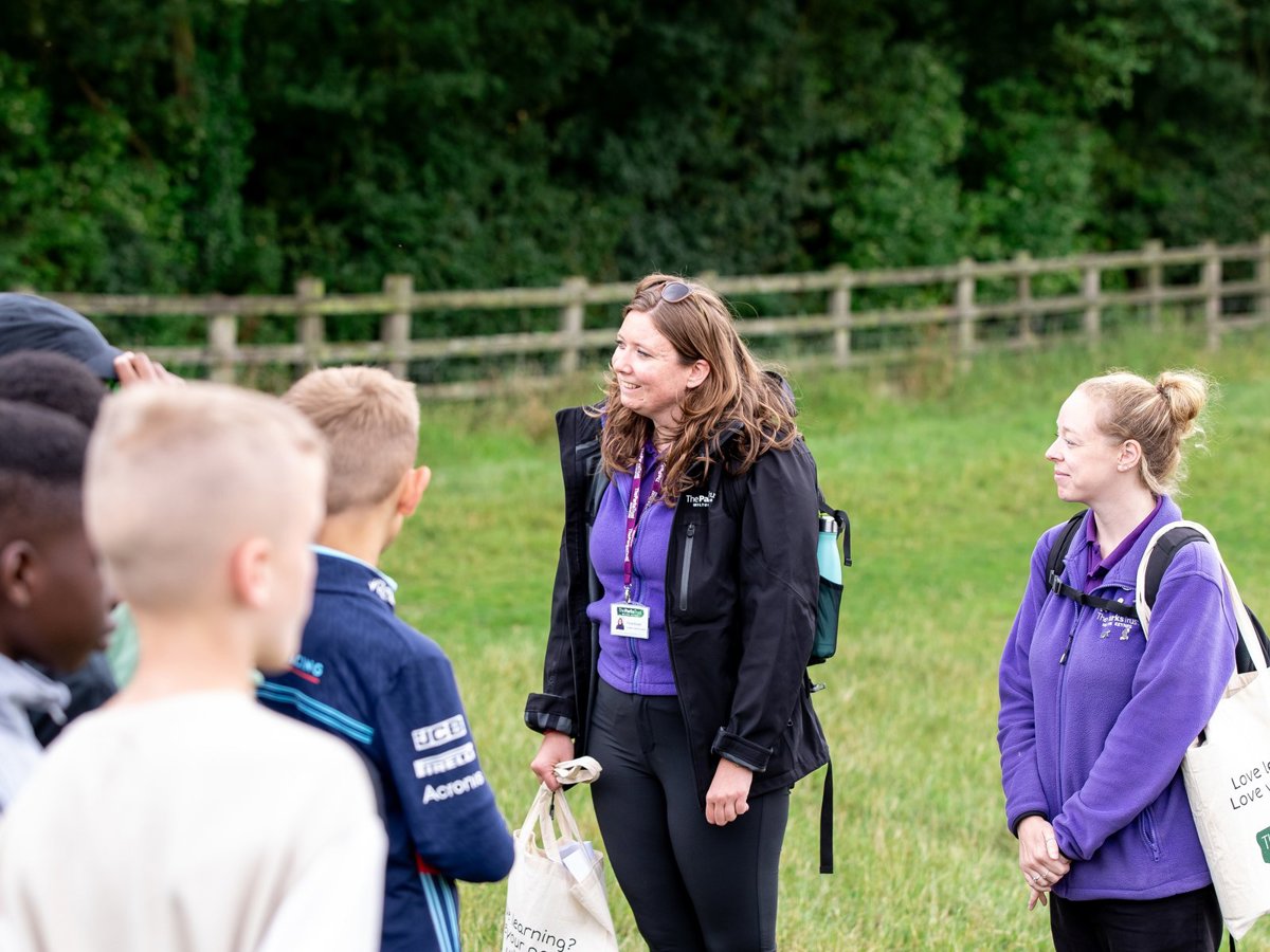 Two Outdoor Learning Leaders in purple uniform with school group