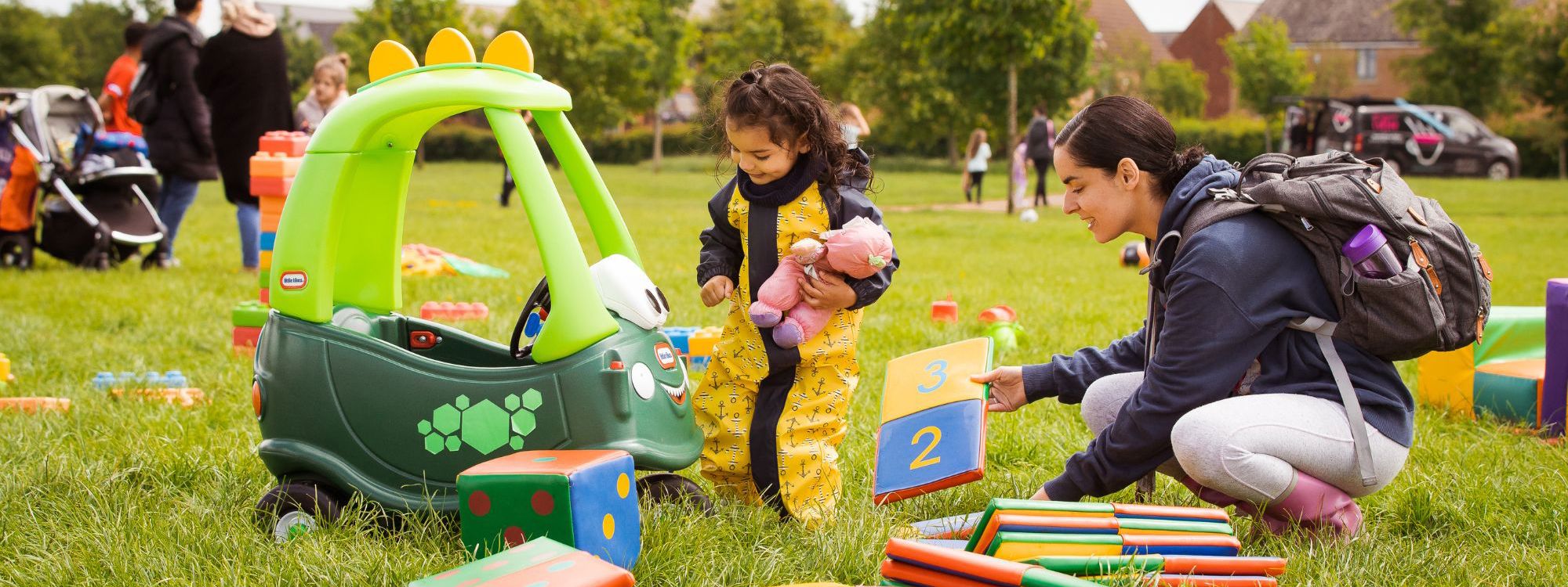 Parent and child playing with outdoor toys and toy car