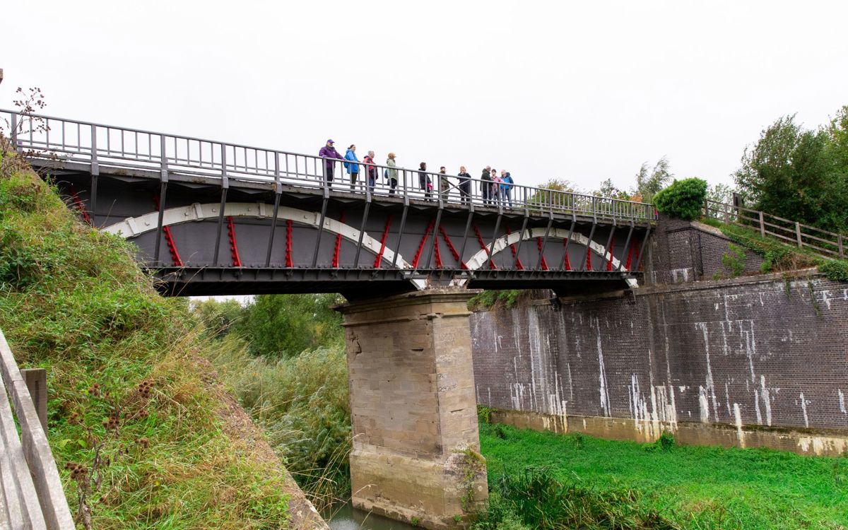 People standing on iron aqueduct bridge