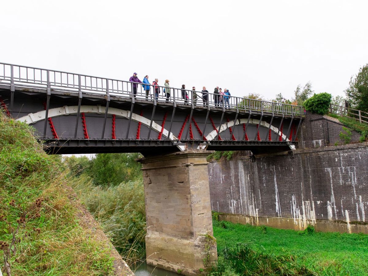 People standing on iron aqueduct bridge