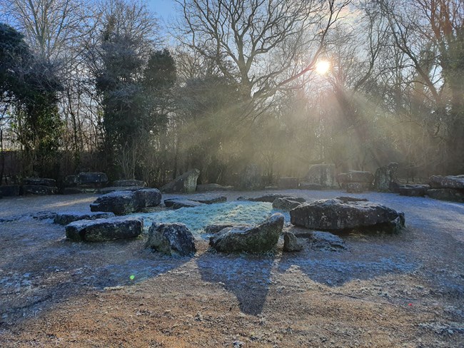 Boulders in frost with sunbeams.