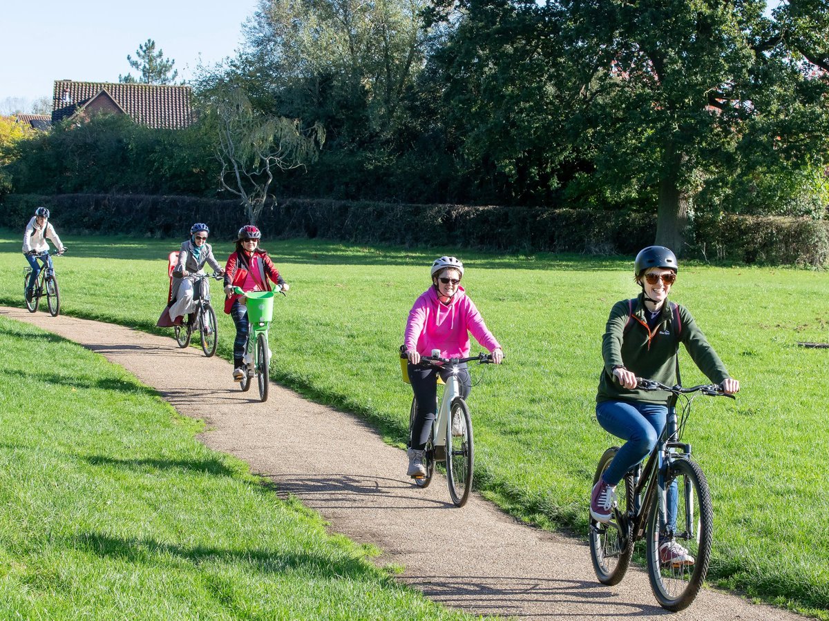Female cyclists in a green parkland scene