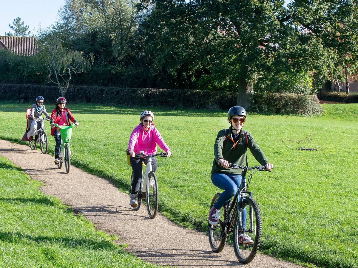 Female cyclists in a green parkland scene