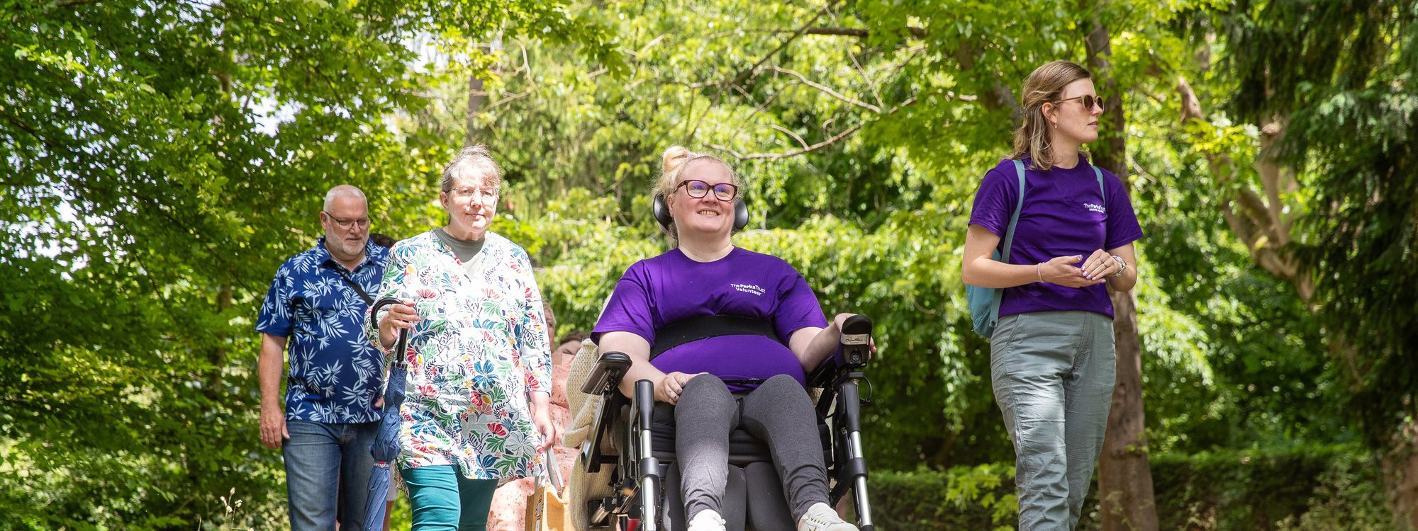A group on a walk being led by a person using a wheelchair