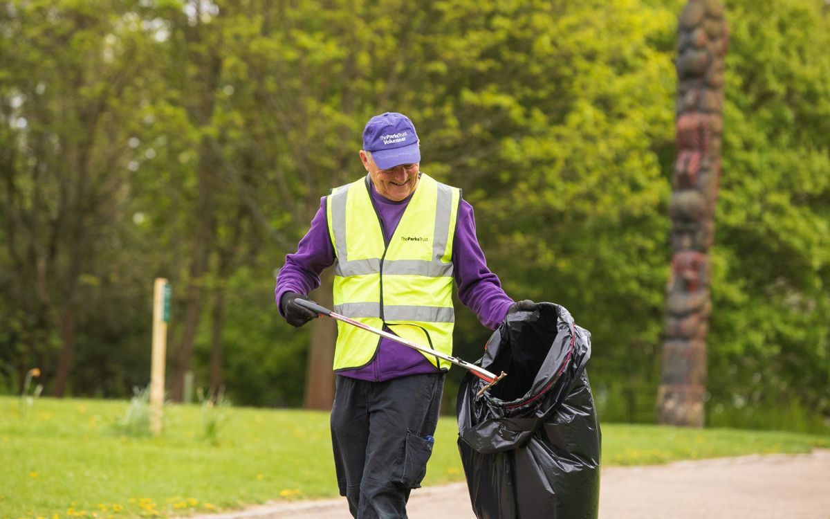 Volunteer picking litter with black bag 