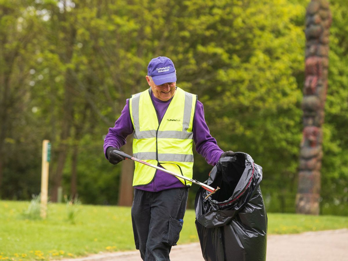Volunteer picking litter with black bag 