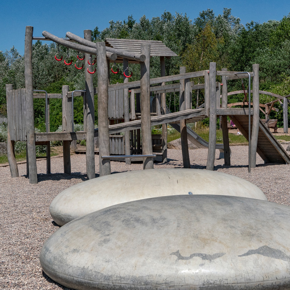 Play equipment with large pebbles in foreground.