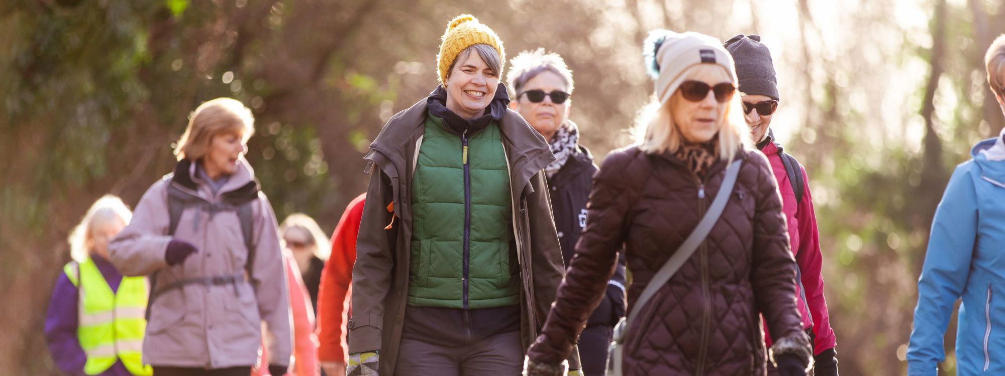 A group of women walking in a parkland scene. 