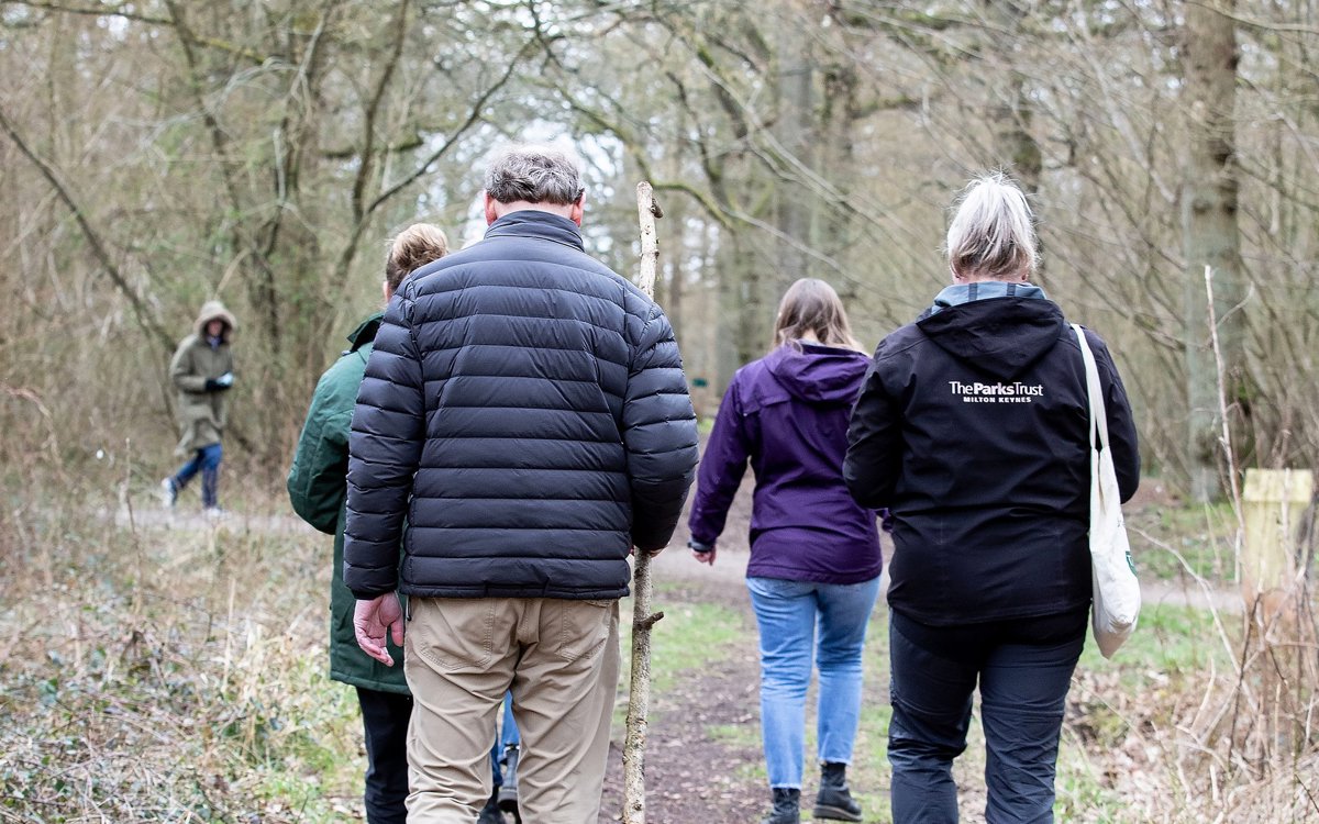 Group of people walking through woodland in winter