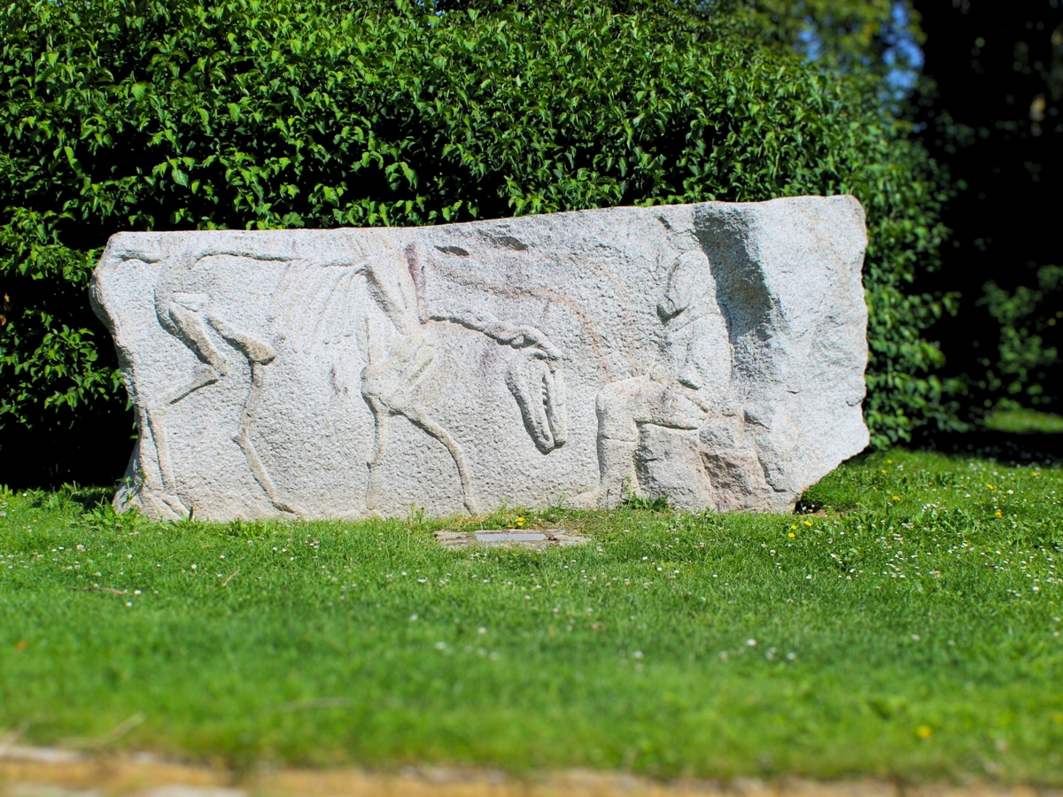 this is a large rectangular stone of which a skeleton of an animal has been created as well as a person