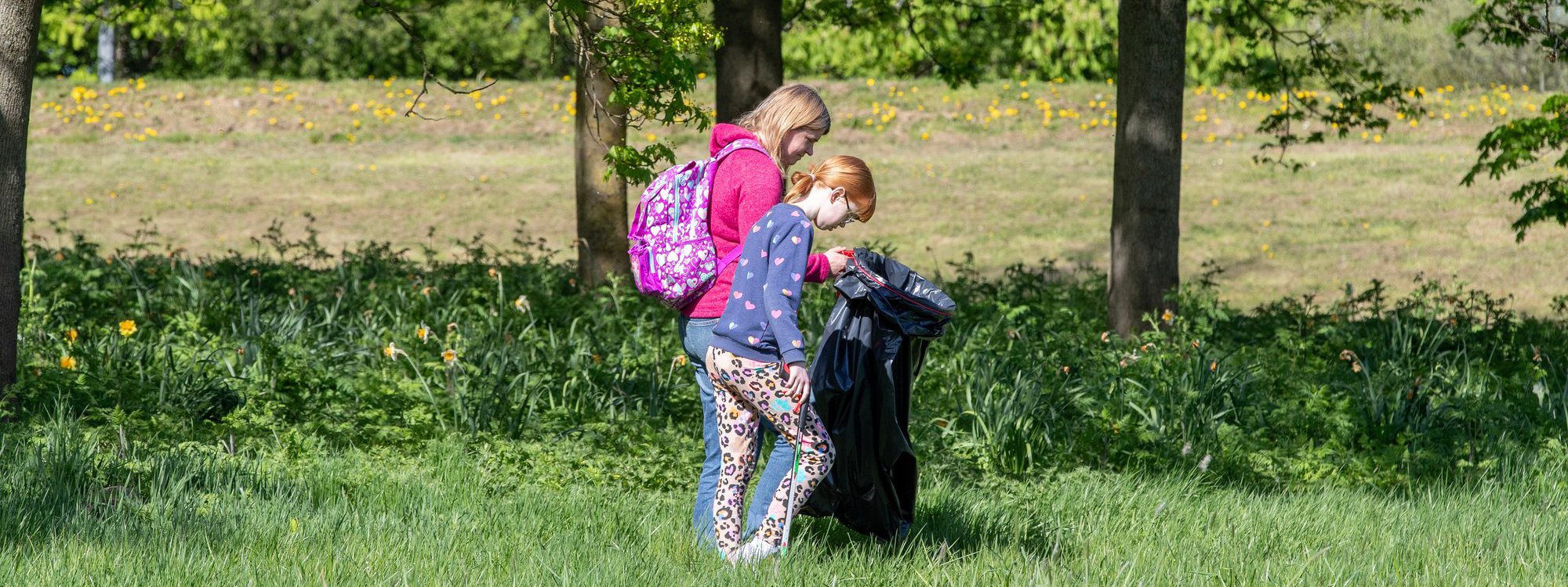 Youngsters litter picking in a parkland scene