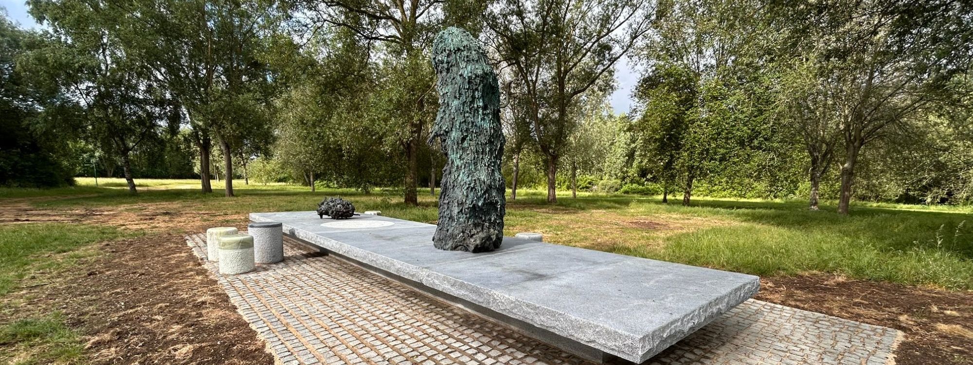Art sculpture in parkland with trees behind