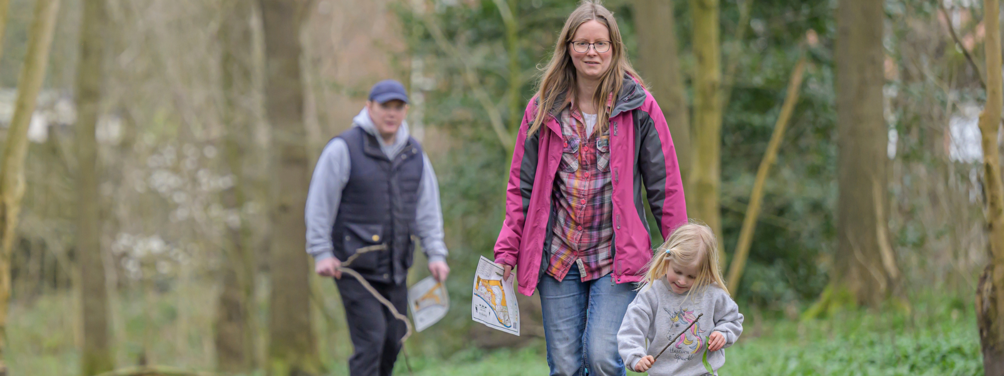 Family in a woodland on an orienteering activity