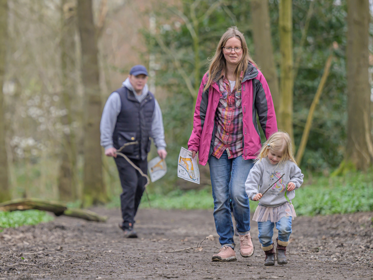 Family in a woodland on an orienteering activity