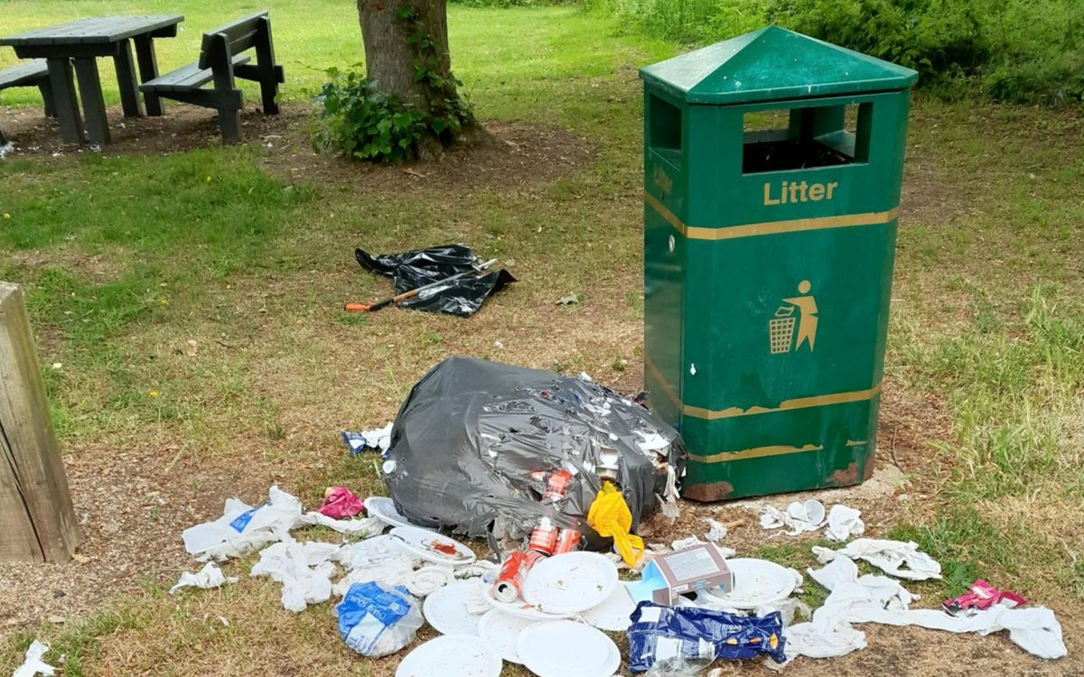 Litter bin and rubbish by the side