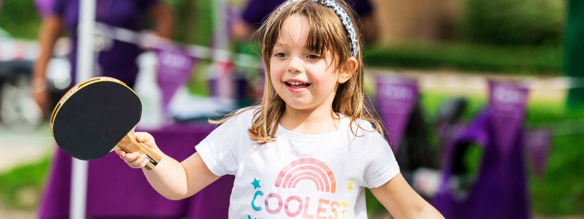 Young child playing table tennis outdoors
