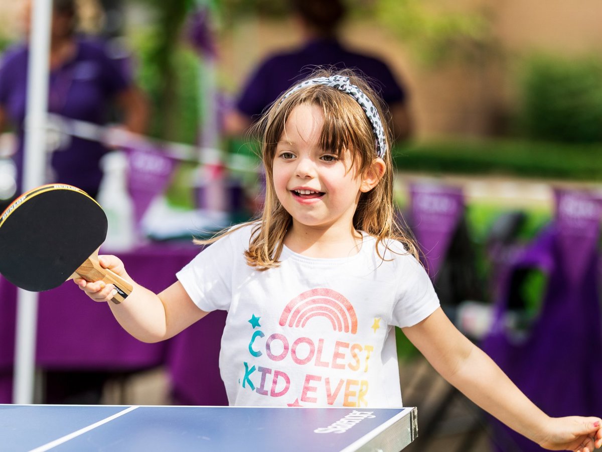 Young child playing table tennis outdoors