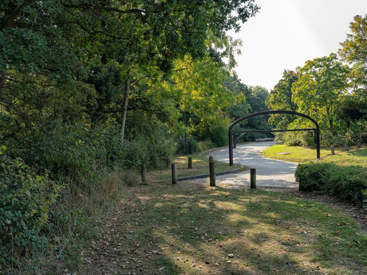 Entrance to Linford Wood car park with trees and height barrier
