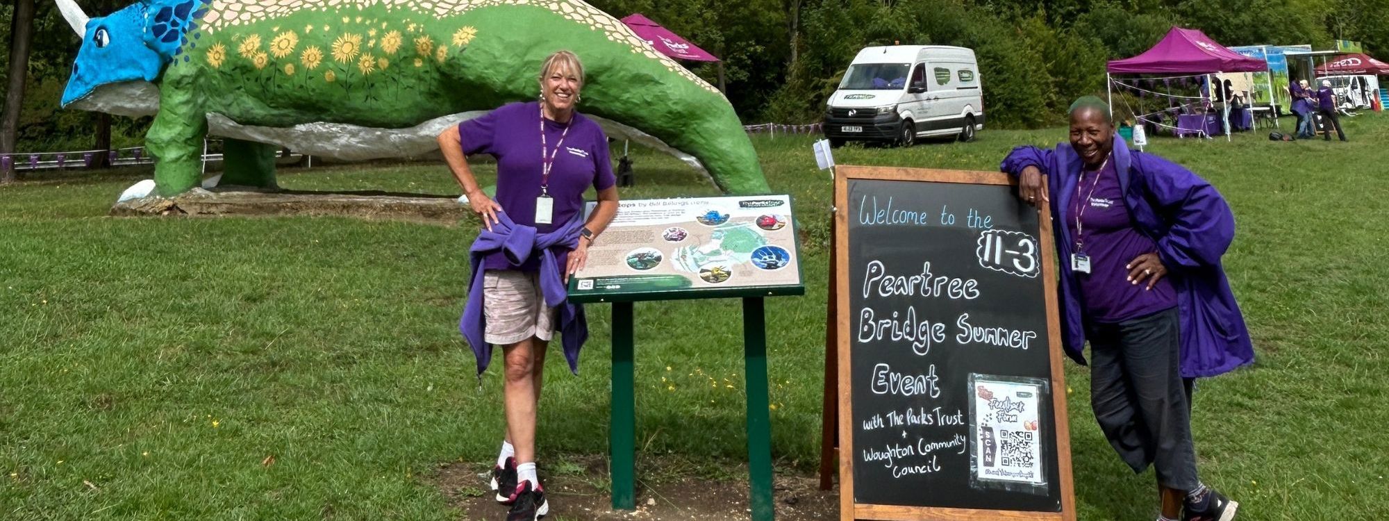 Parks Trust volunteers posing in front of the Triceratops sculpture in Peartree Bridge 