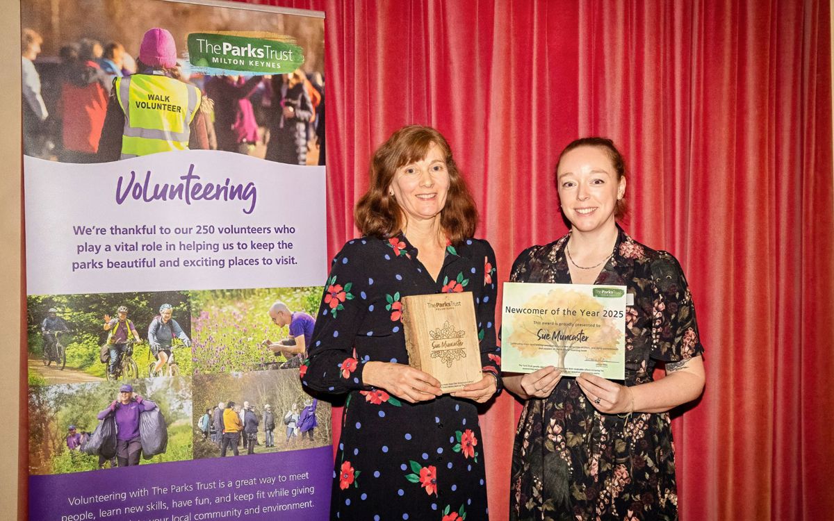 Sue and Amy holding volunteer certificate and trophy