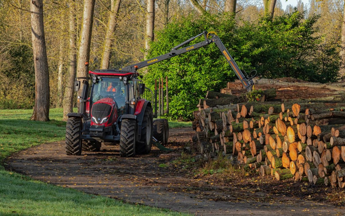 Tractor moving logs on to pile in Milton Keynes park