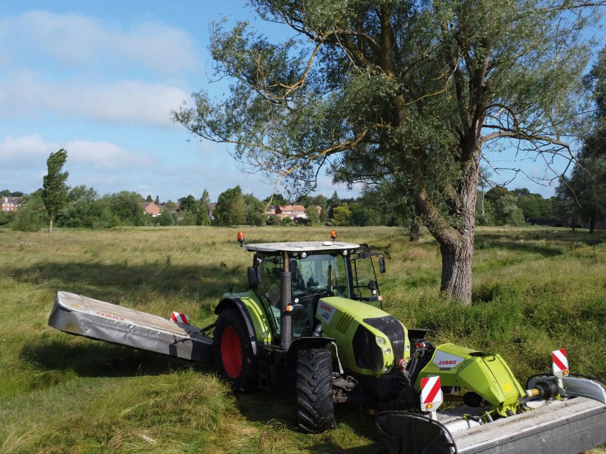 Tractor cutting hay in Milton Keynes field