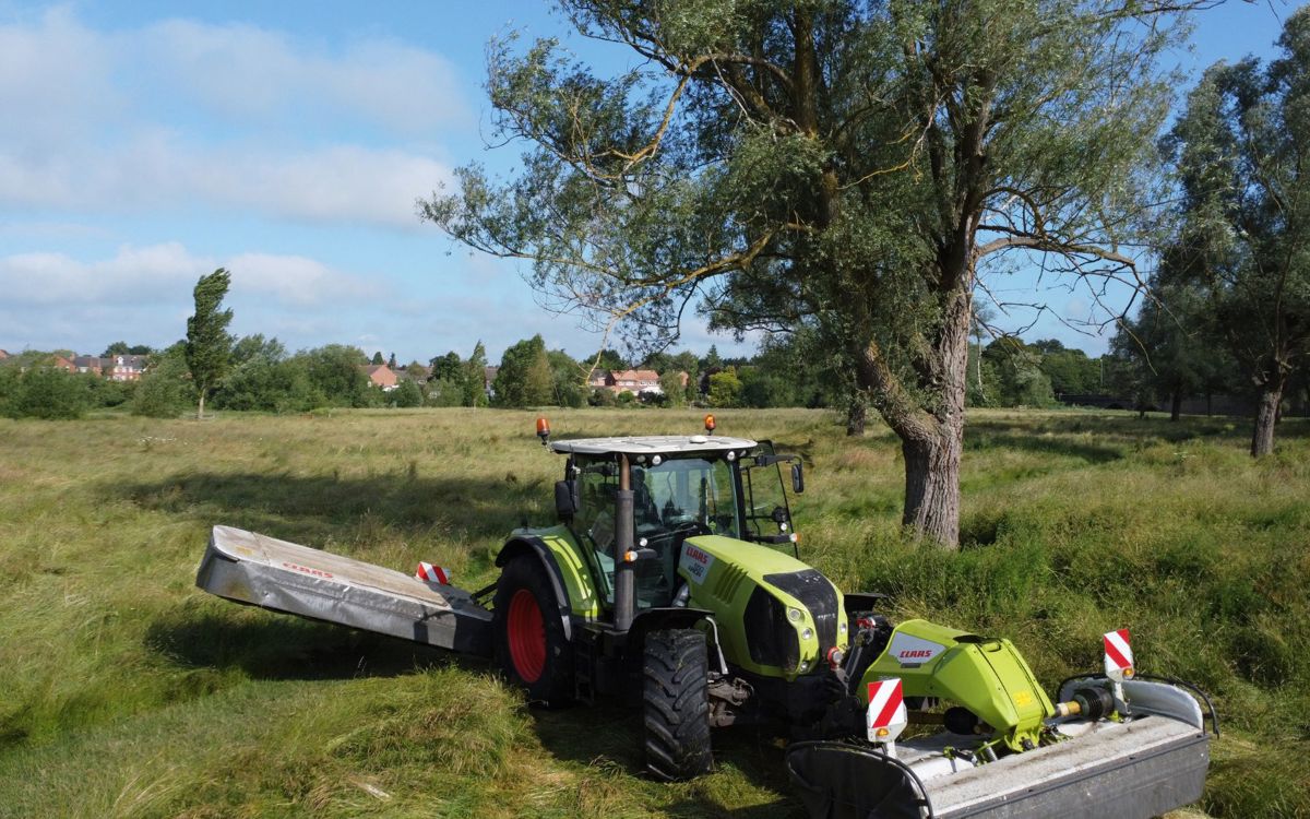 Tractor cutting hay in Milton Keynes field