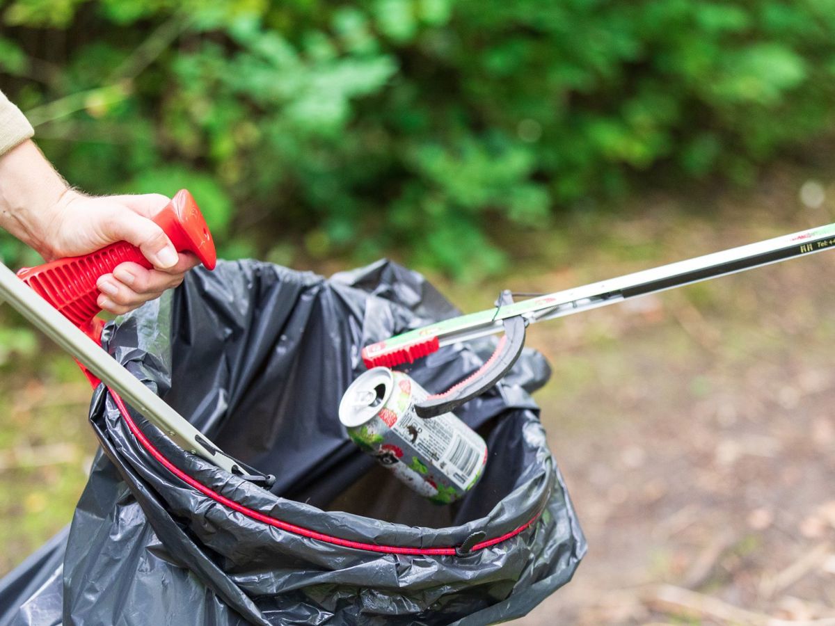 Litter pickers picking up can and dropping into black bin bag