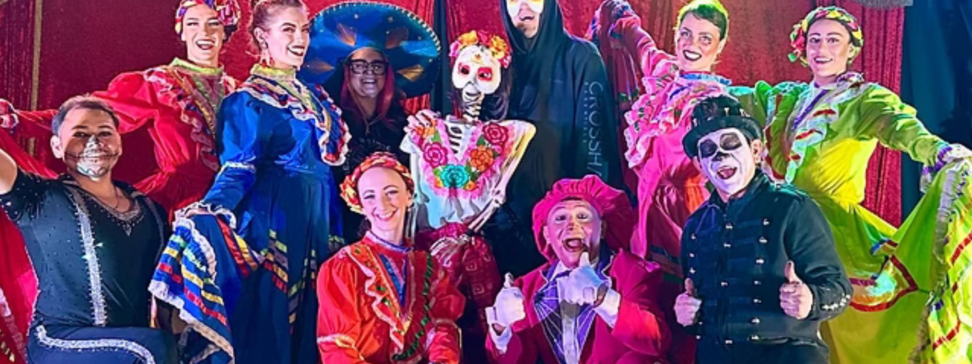 Tequila Circus performers, in their costumes, taking a group picture 