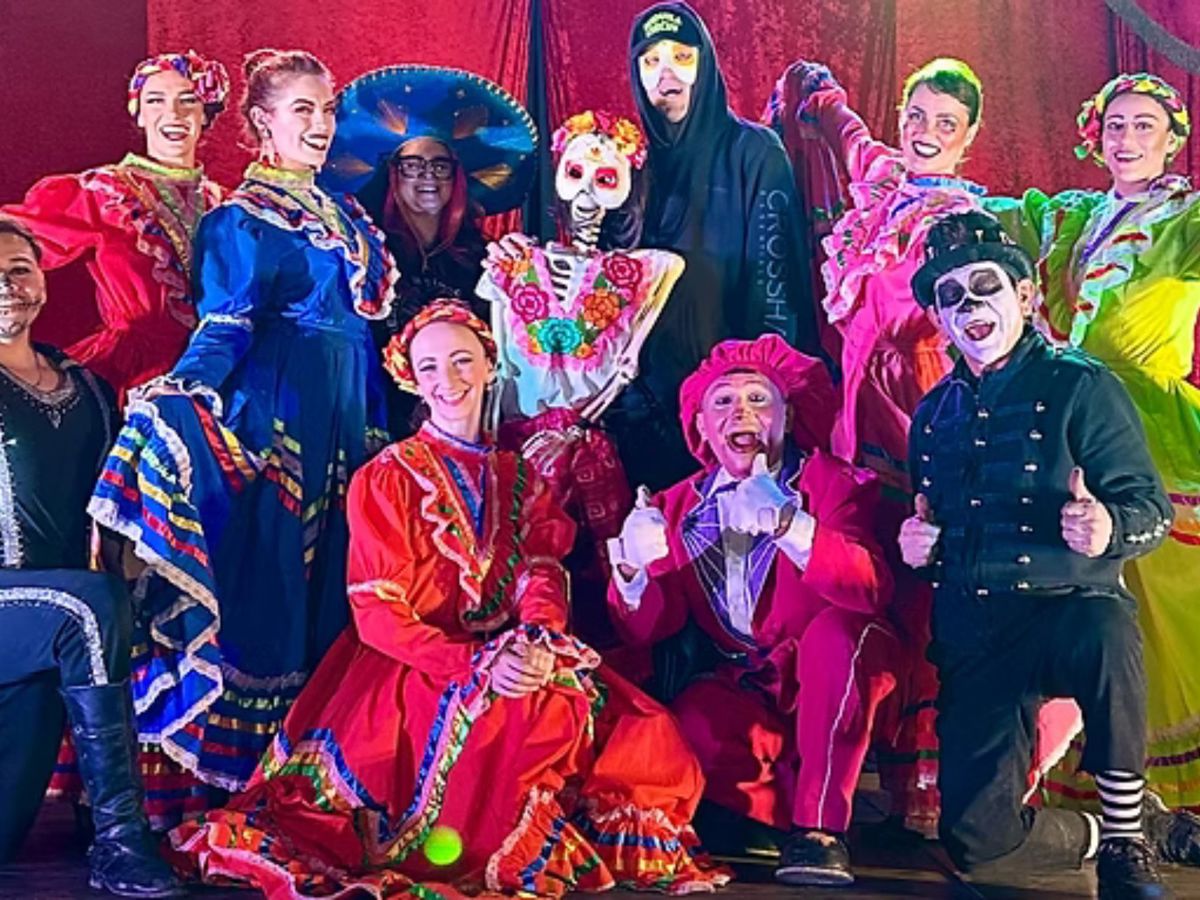 Tequila Circus performers, in their costumes, taking a group picture 
