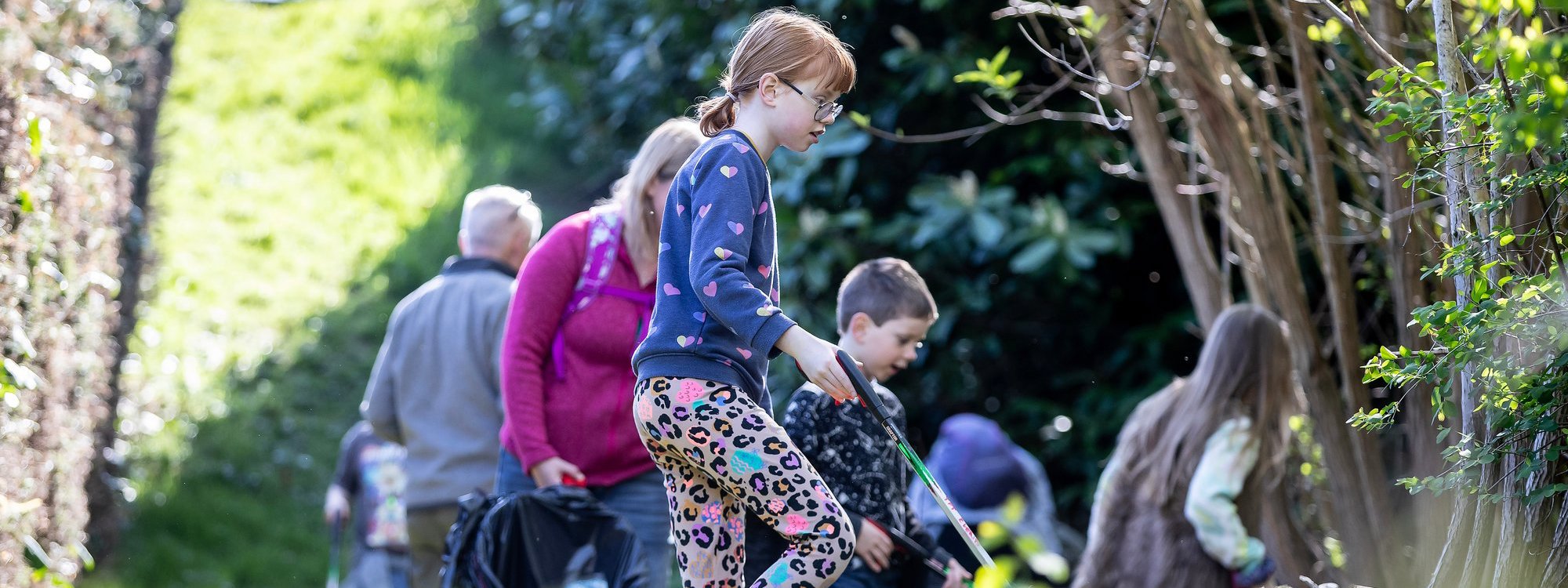 Youngsters litter picking in a parkland scene