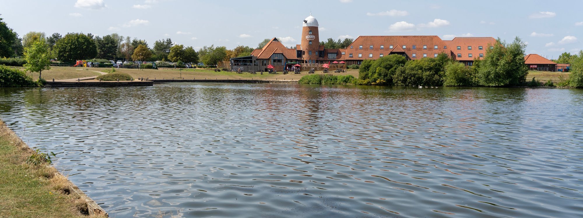 Lake with pub in old windmill in background 