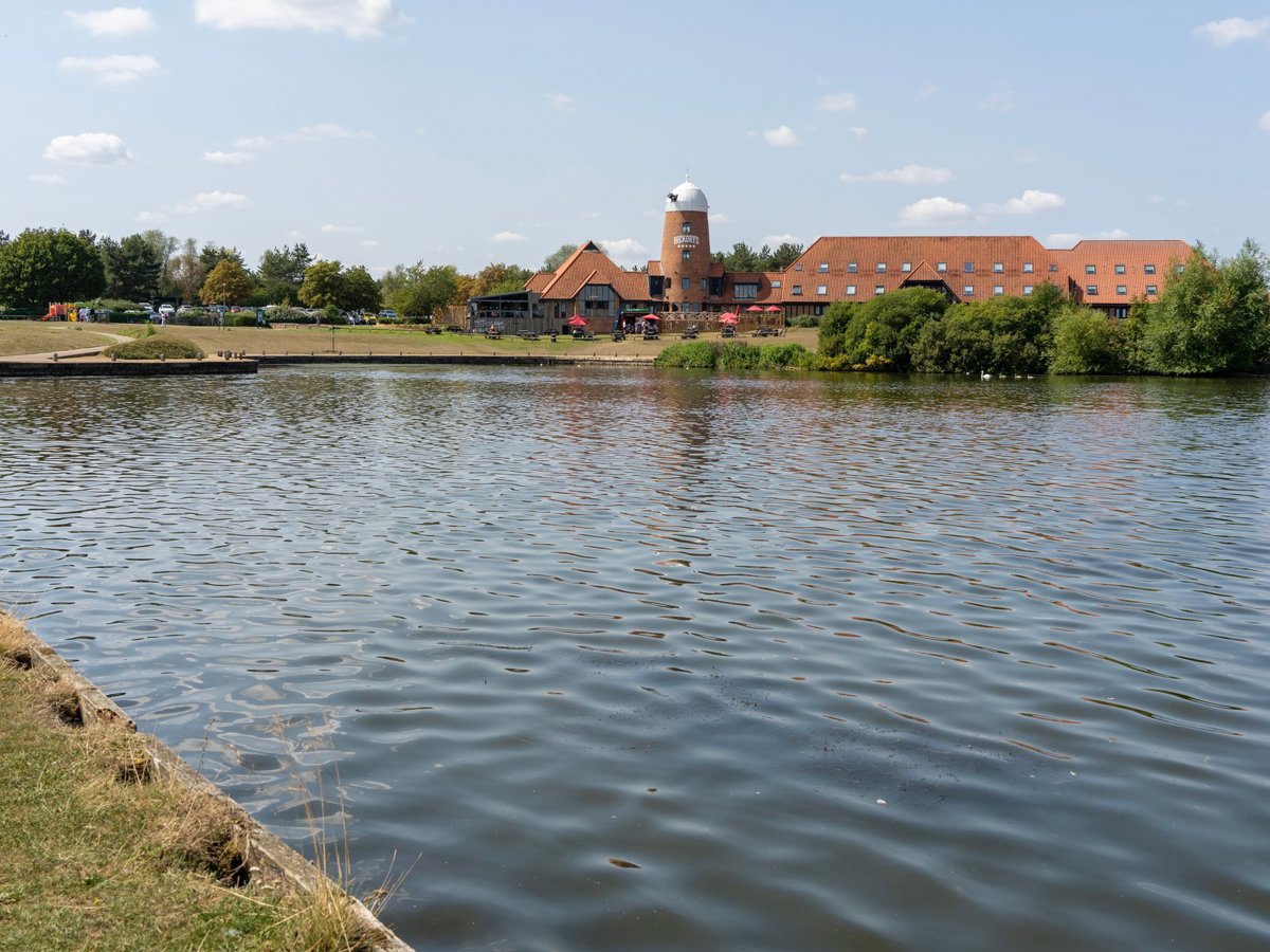 Lake with pub in old windmill in background 