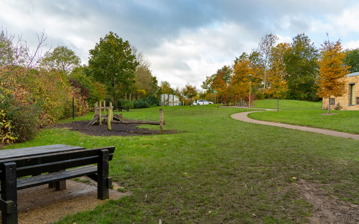 Building, picnic benches and play area at Howe Park Wood.