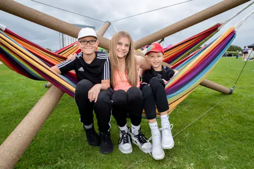 three teens sitting on the hammock