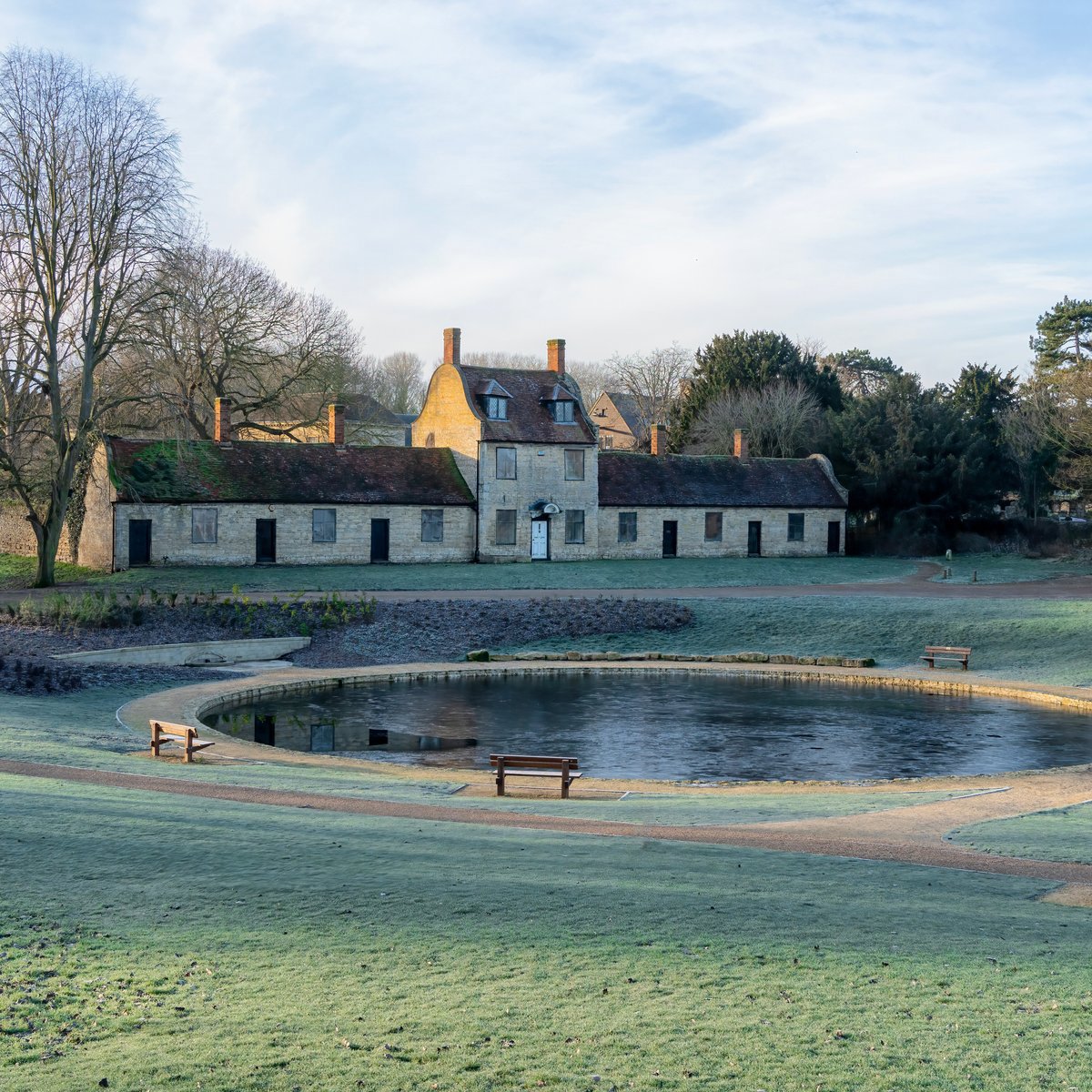 Almshouse buildings with frozen pond in park
