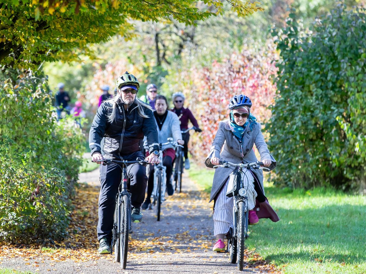 Cyclists cycling towards the camera in a parkland scene 
