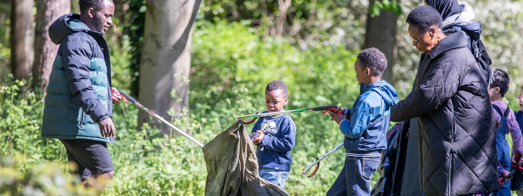 Youngsters litter picking in a parkland scene