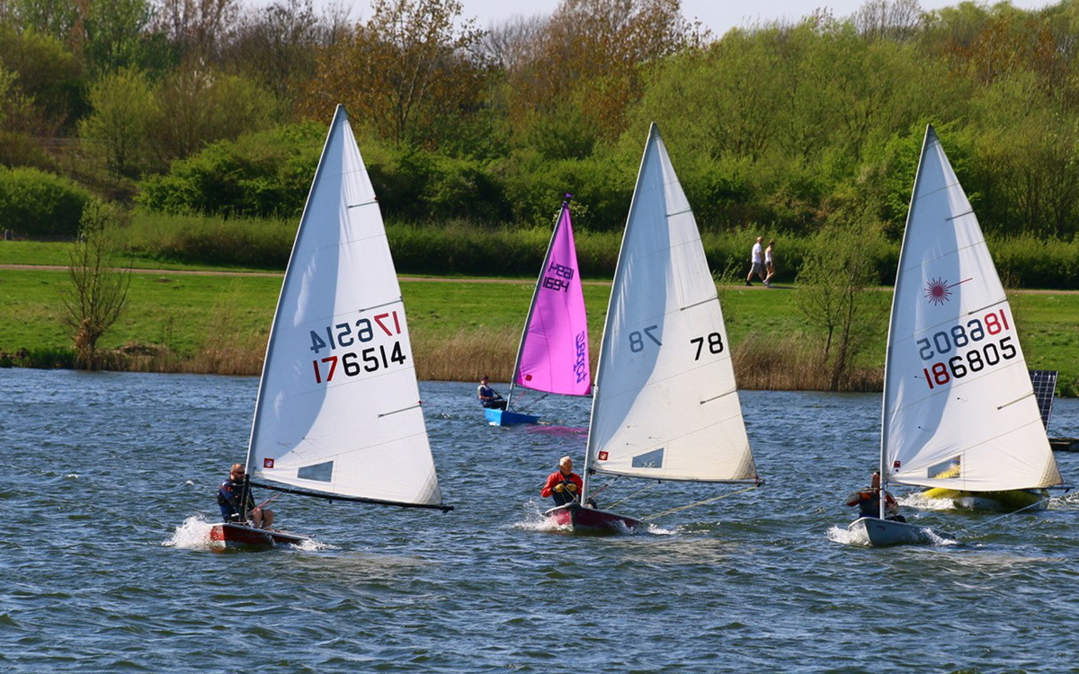 4 sailing boats on a lake.