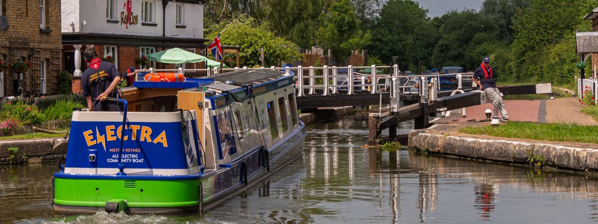 Image, indicating Electra, Red Lion boat at the Fenny Lock. Blue and green boat with yellow Electra Logo