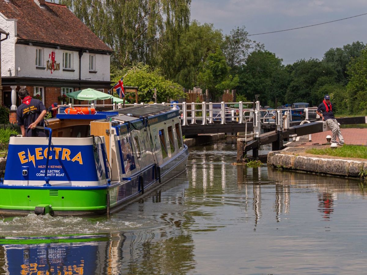 Image, indicating Electra, Red Lion boat at the Fenny Lock. Blue and green boat with yellow Electra Logo