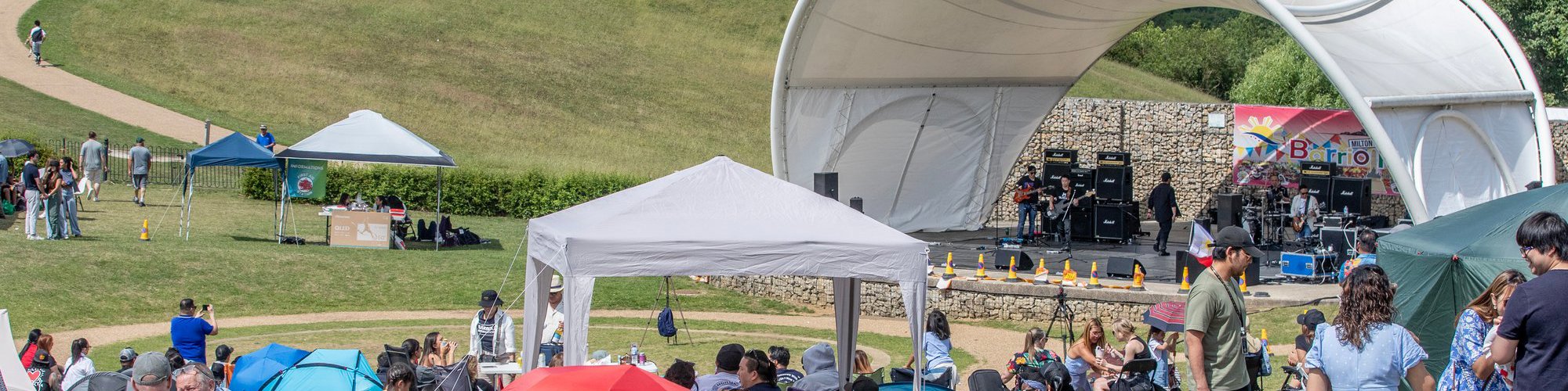 people sat on the grass at the Campbell Park Amphitheatre for the Filipino festival 